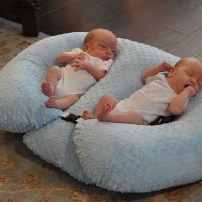 Coussin d'allaitement jumeaux naissant sur le dos