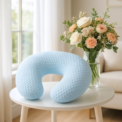 coussin d'allaitement bleu près d'un bouquet de fleurs